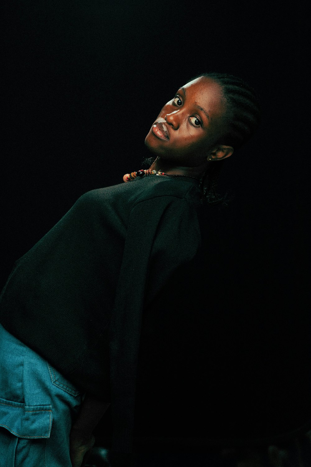 une femme avec des dreadlocks debout dans le noir