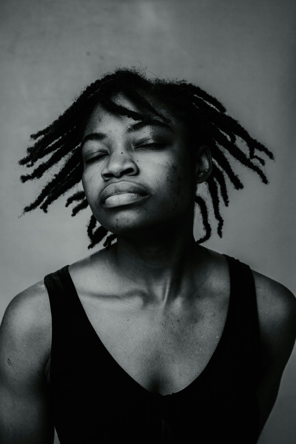 a black and white photo of a woman with dreadlocks