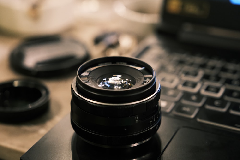 a camera lens sitting on top of a laptop computer