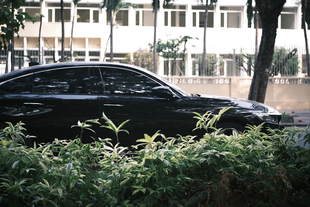 a black car parked in front of a tall building