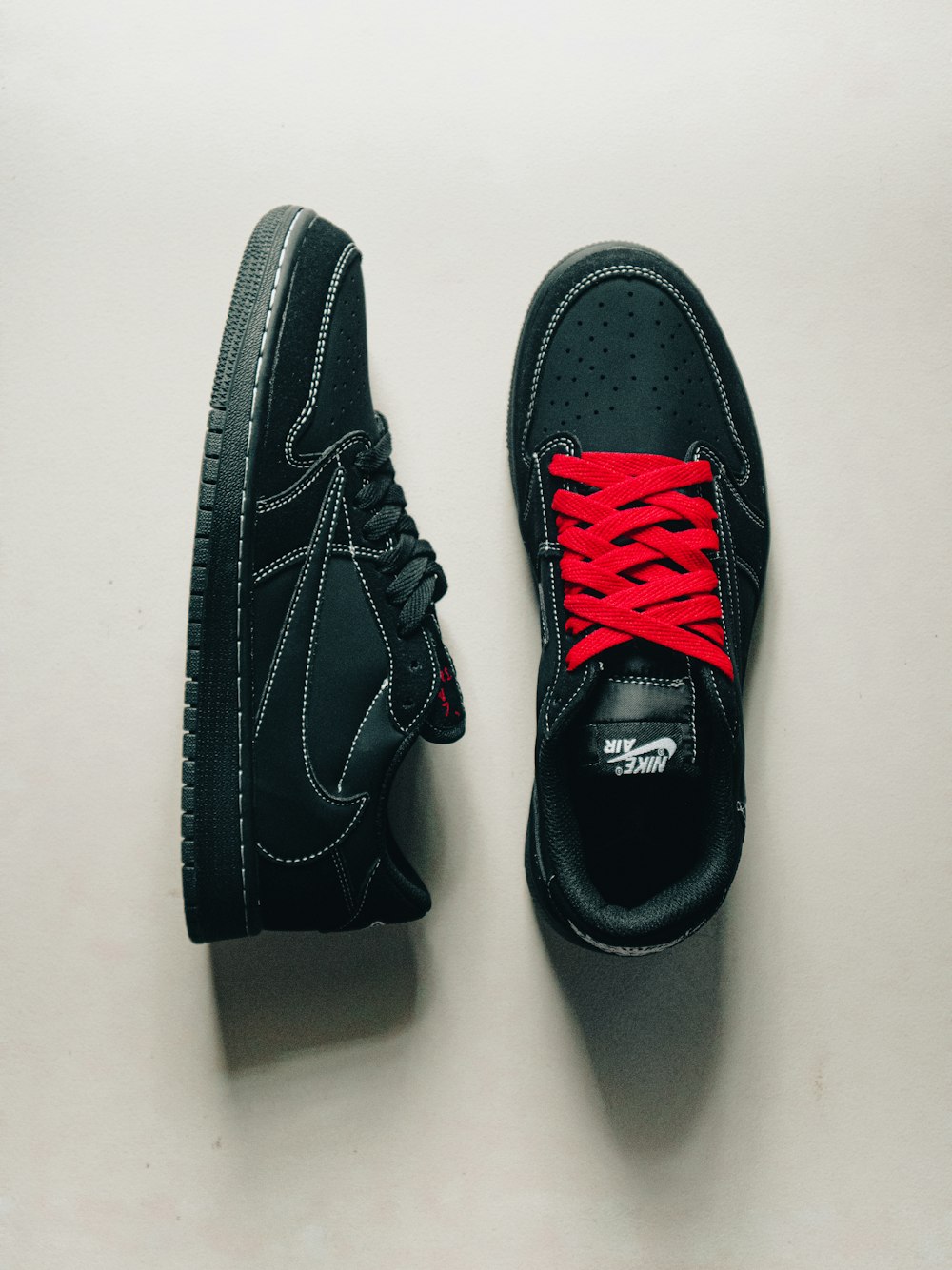 a pair of black sneakers with red laces