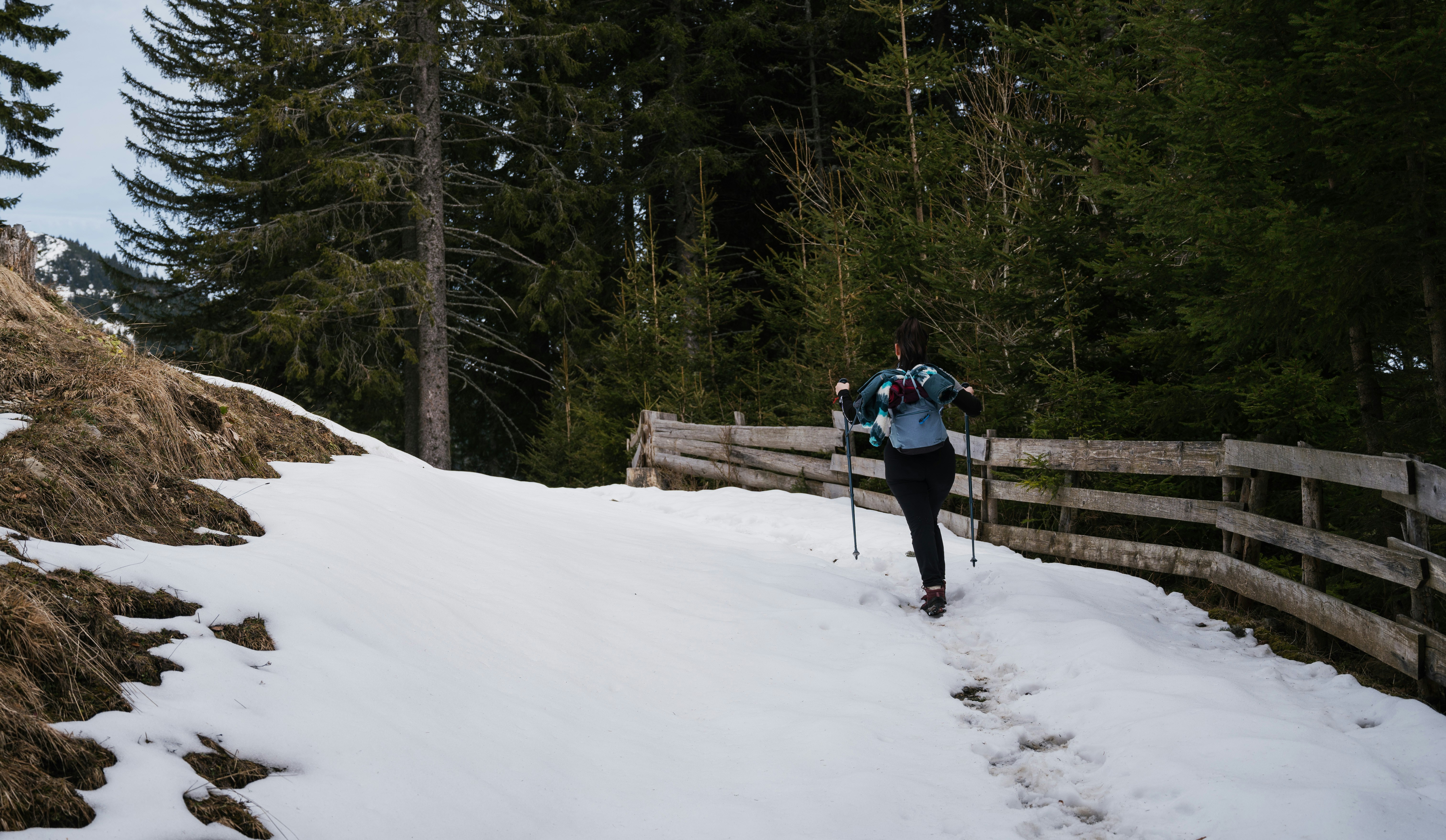 a person walking up a snowy hill on skis