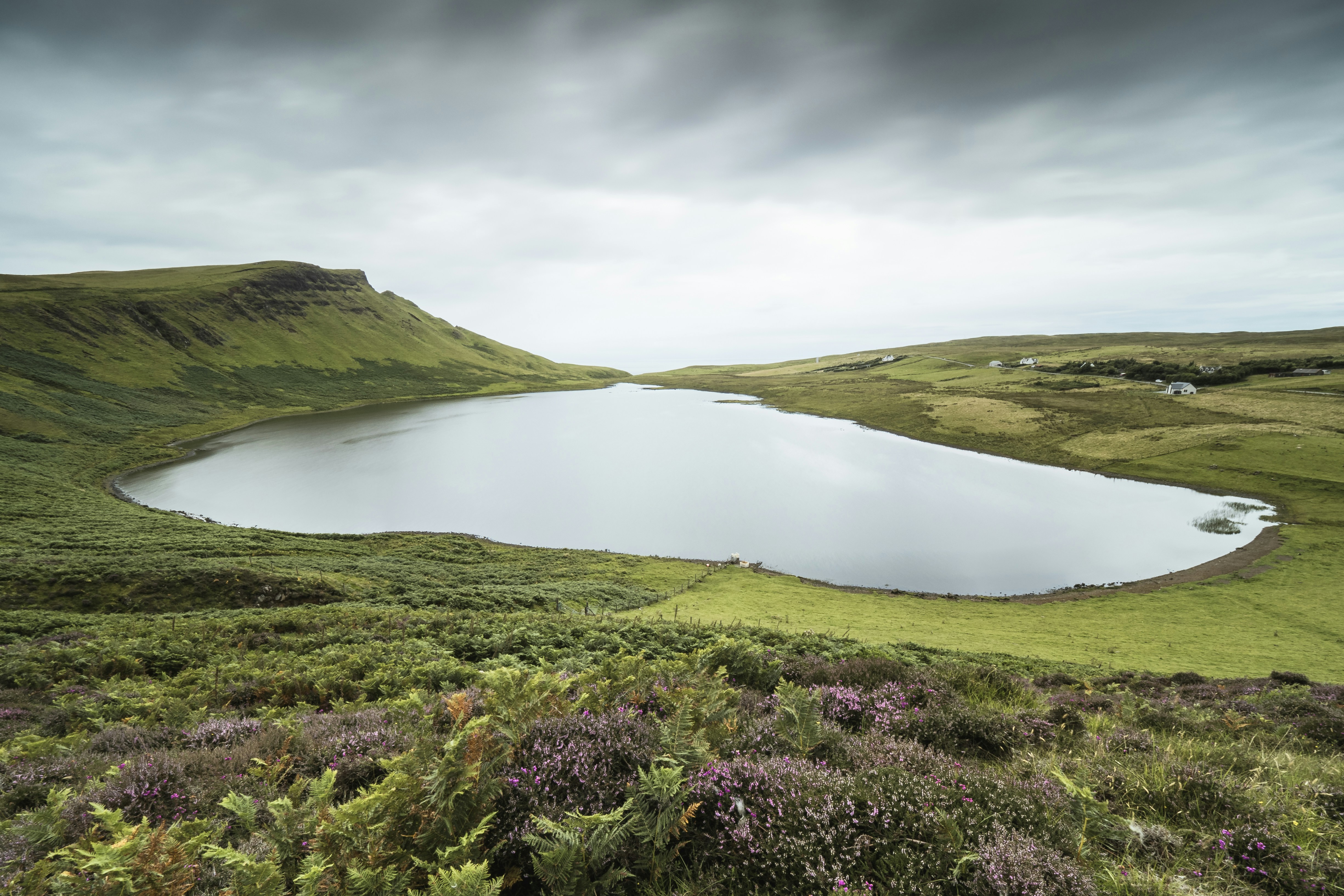 a large body of water surrounded by lush green hills