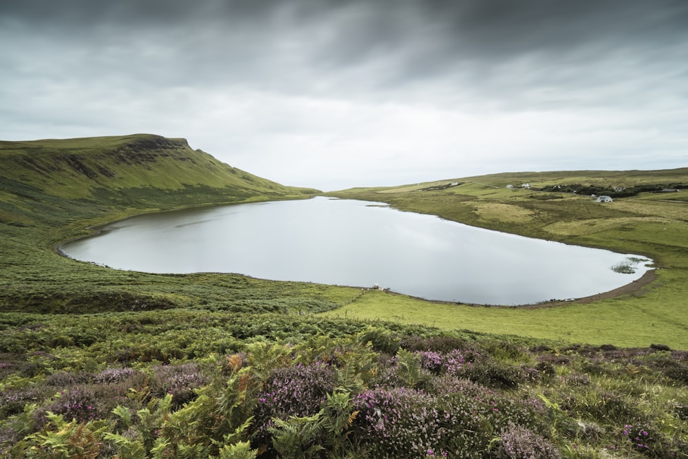 a large body of water surrounded by lush green hills