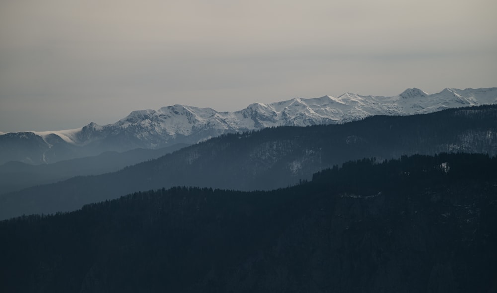 a mountain range with snow covered mountains in the distance