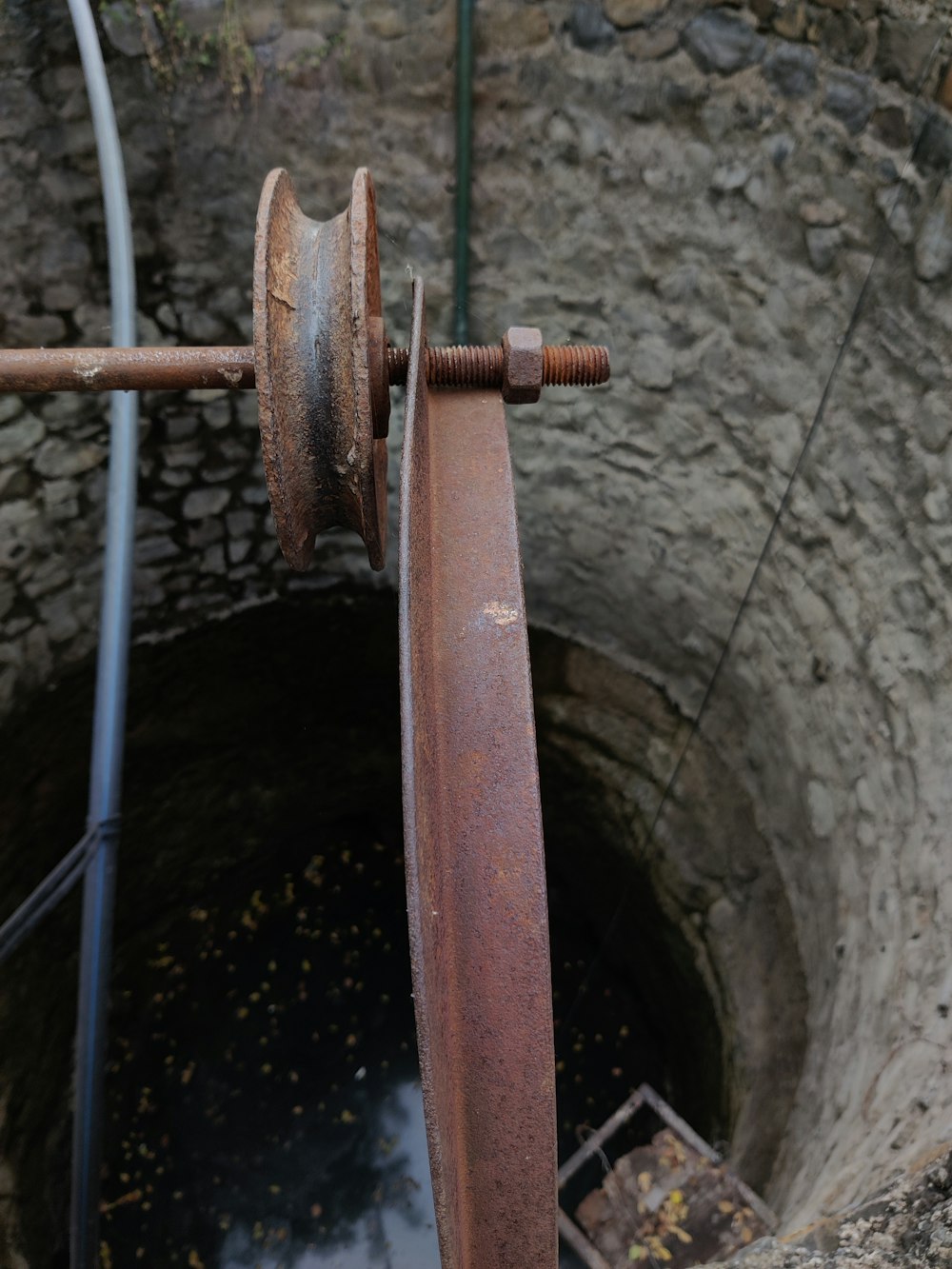 a rusty pipe with a rusted handle in a well