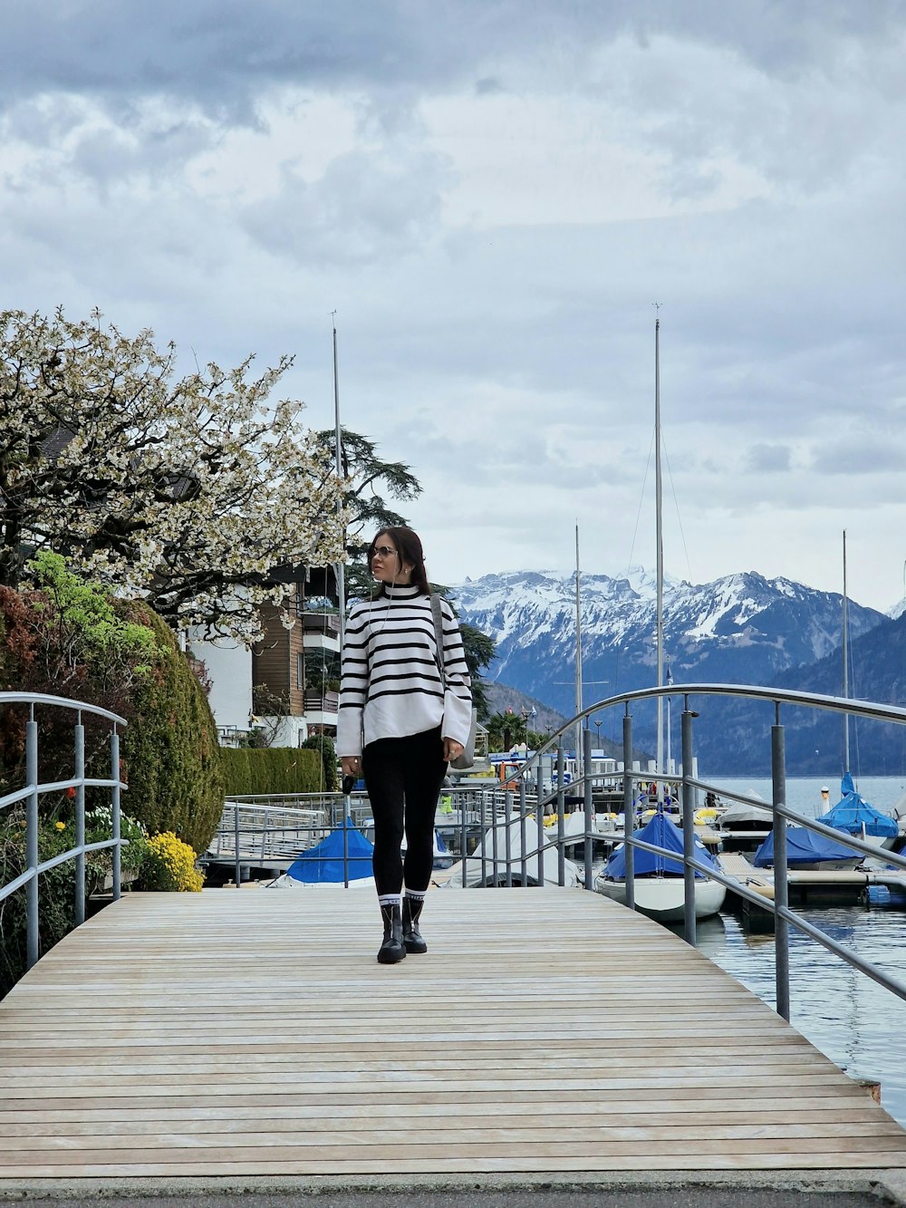 a woman walking down a dock towards a body of water