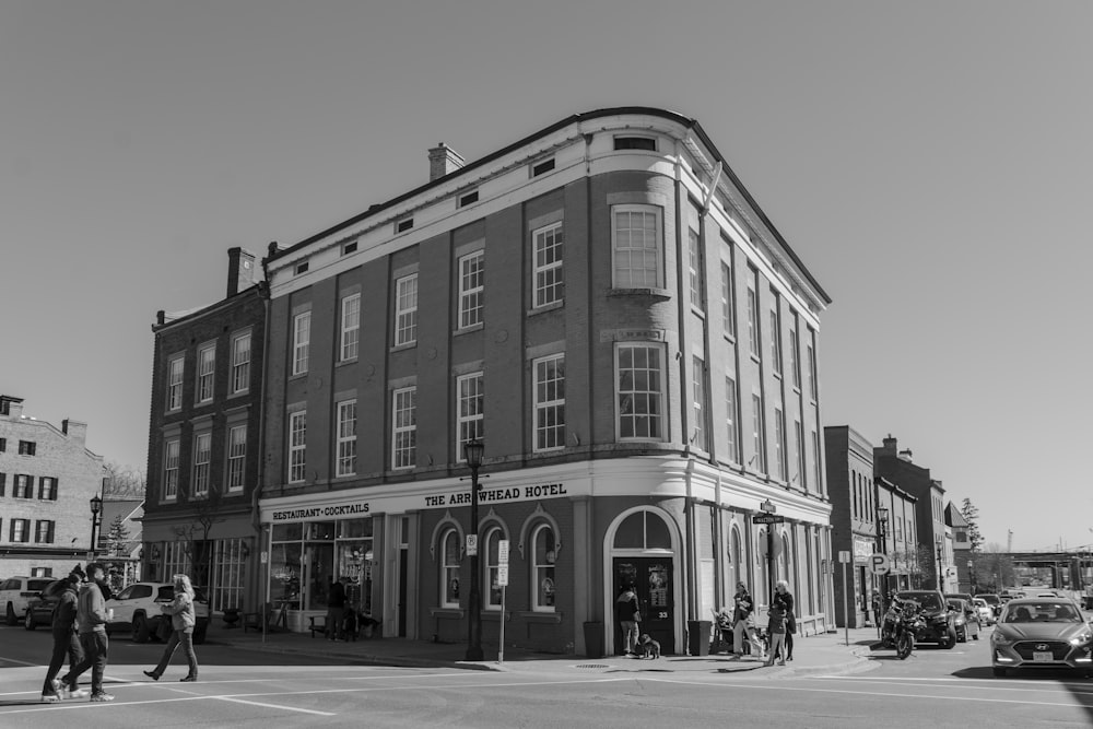 a black and white photo of people crossing the street