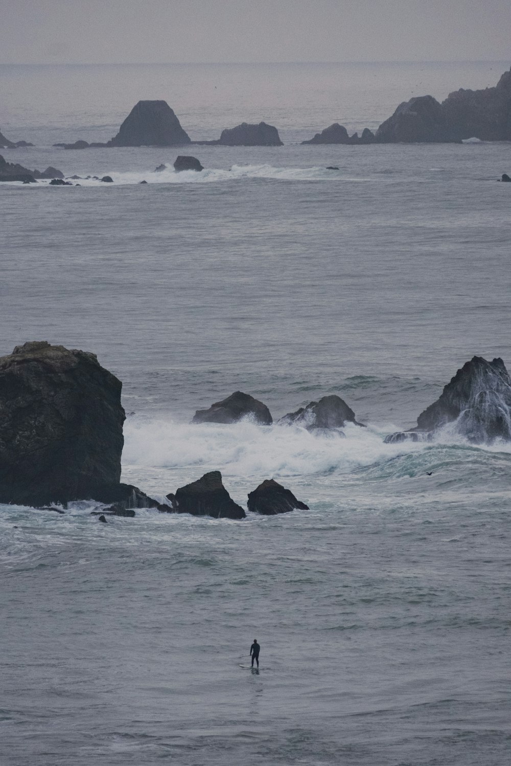 a person standing on a surfboard in the ocean