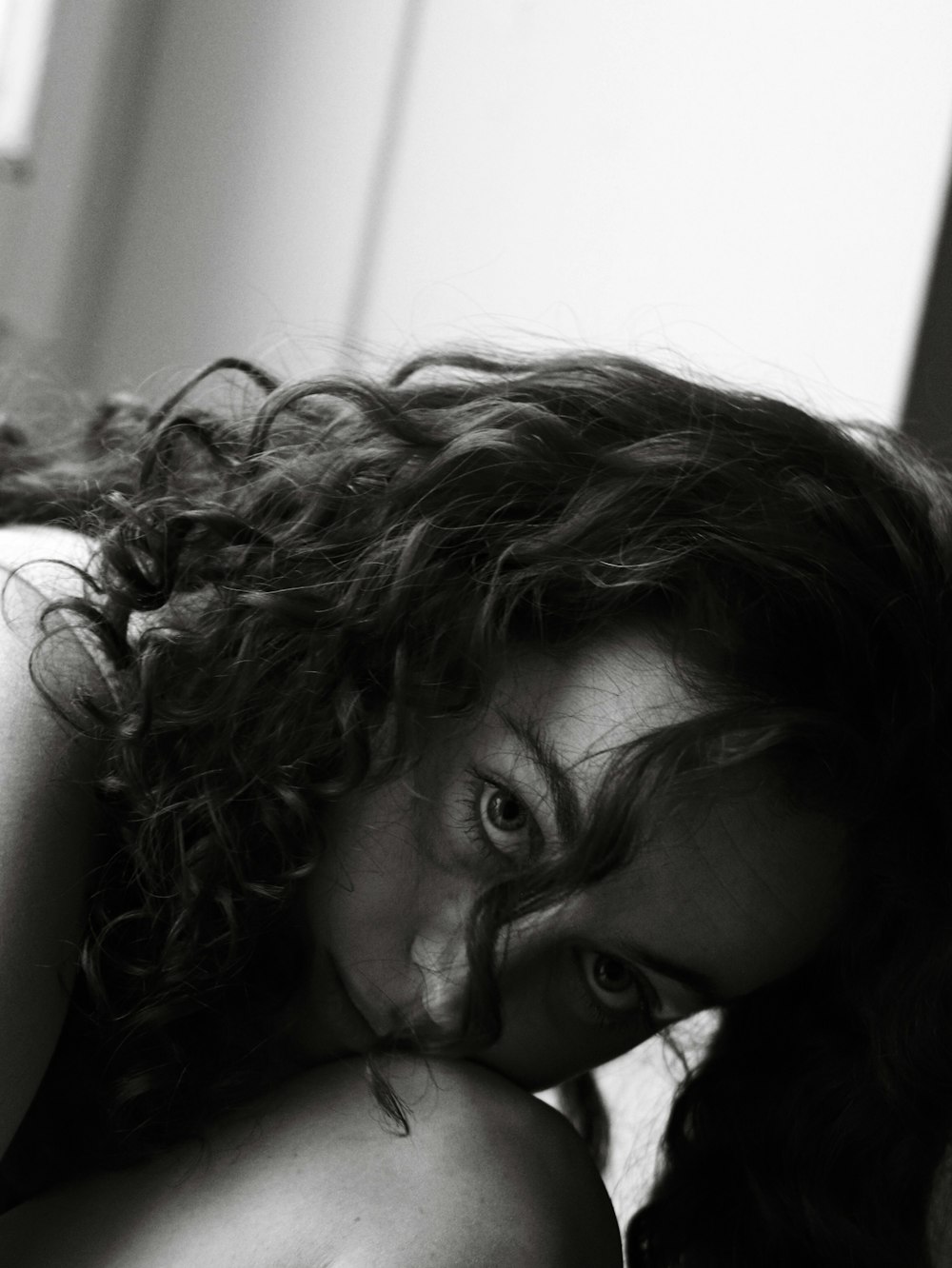 a woman laying on top of a bed next to a window