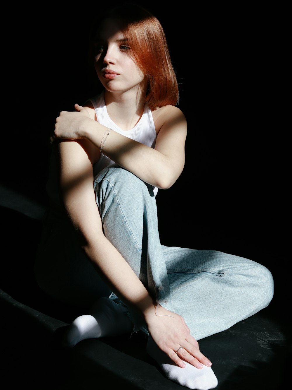a woman with red hair sitting on the ground