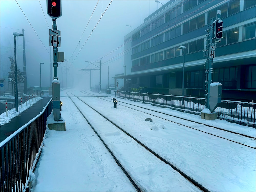 a train track covered in snow next to a building