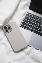 a laptop computer sitting next to a white iphone