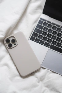 a laptop computer sitting next to a white iphone