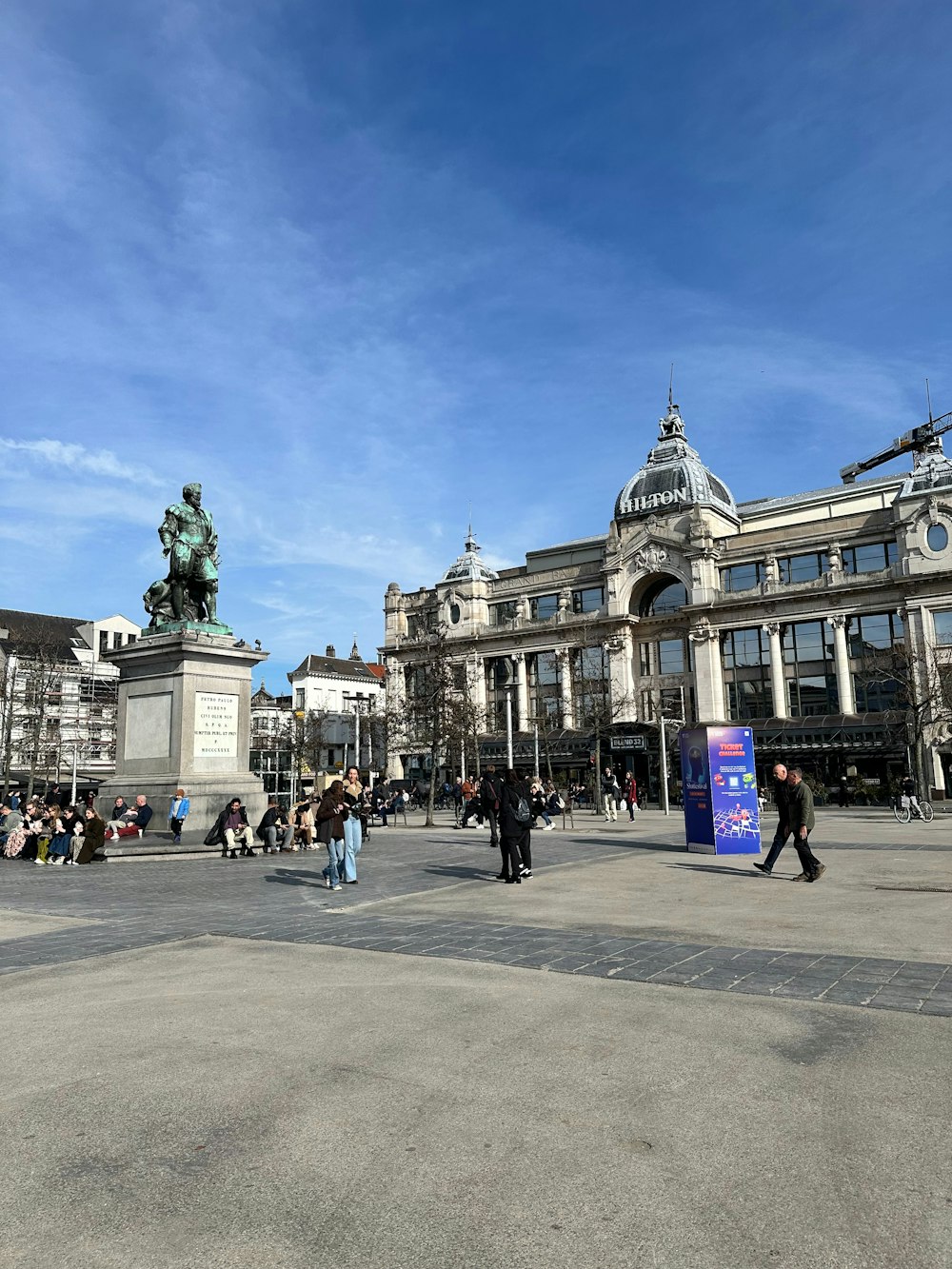 a group of people walking around a city square