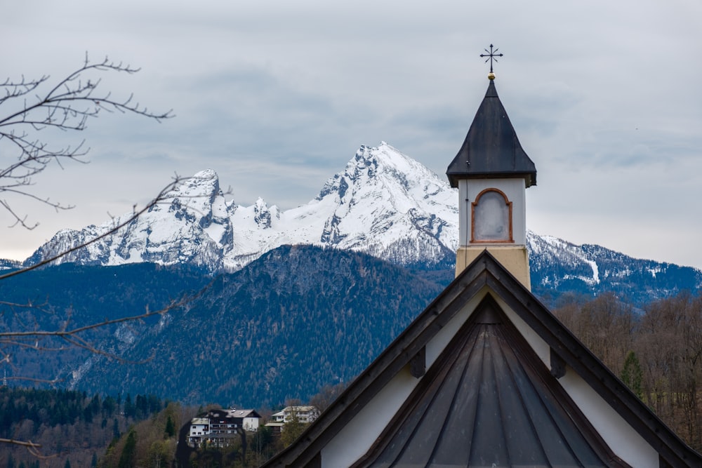 a church steeple with a mountain in the background