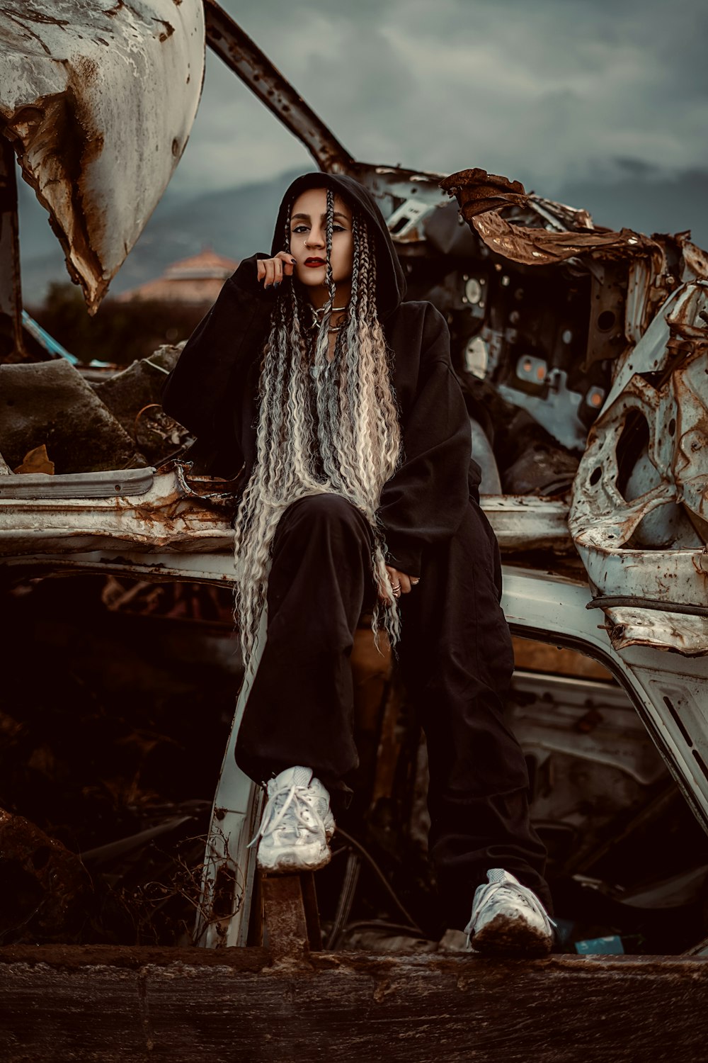 a woman with dreadlocks sitting on top of a car