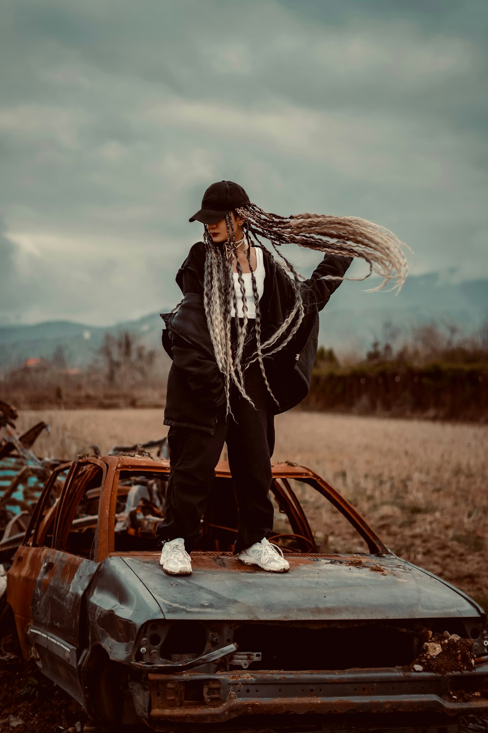 a man with dreadlocks standing on top of a car