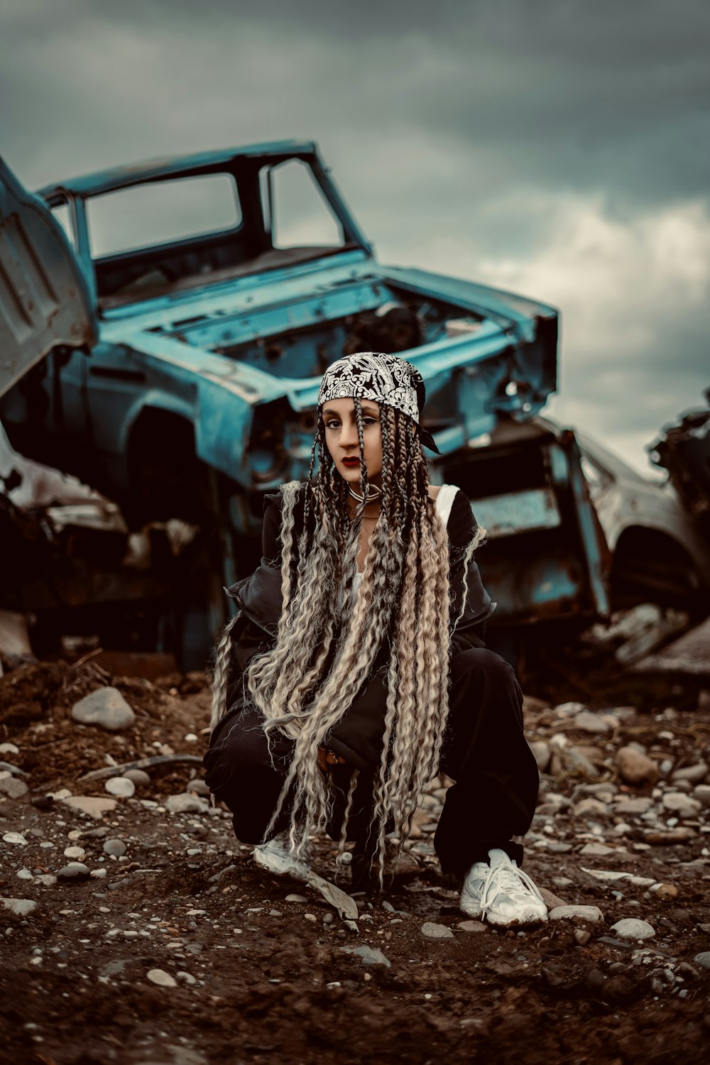 a woman with dreadlocks sitting in front of a truck