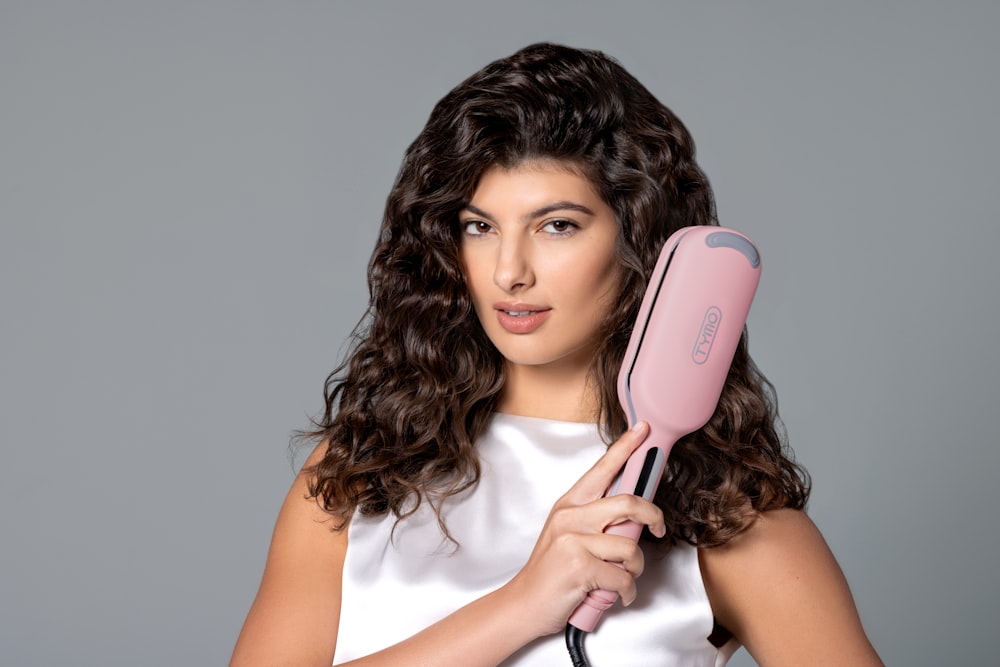 a woman holding a hair dryer in her hand