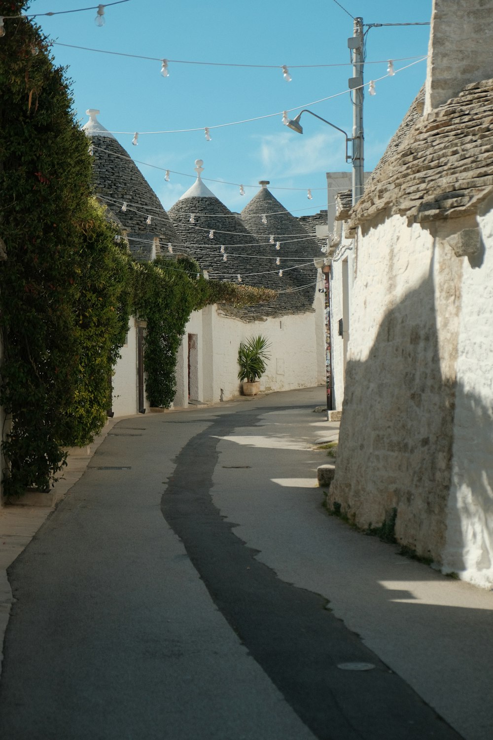 a narrow street with a line of houses in the background