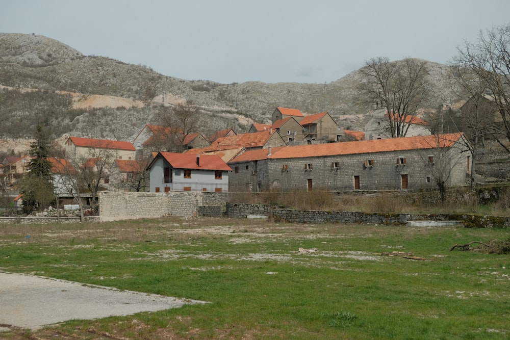 an old building with a red roof sits in the middle of a field