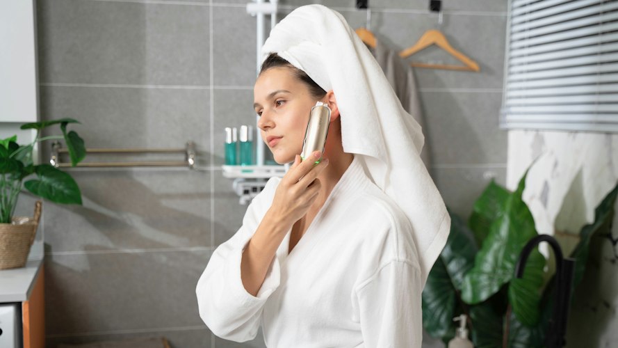 Bathroom counter with a simple skincare routine of cleanser, serum, and sunscreen bottles