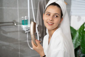 a woman in a bathrobe holding a hair brush