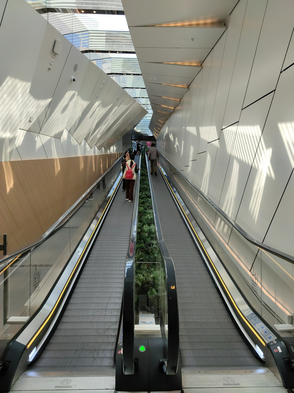 a couple of people riding down an escalator