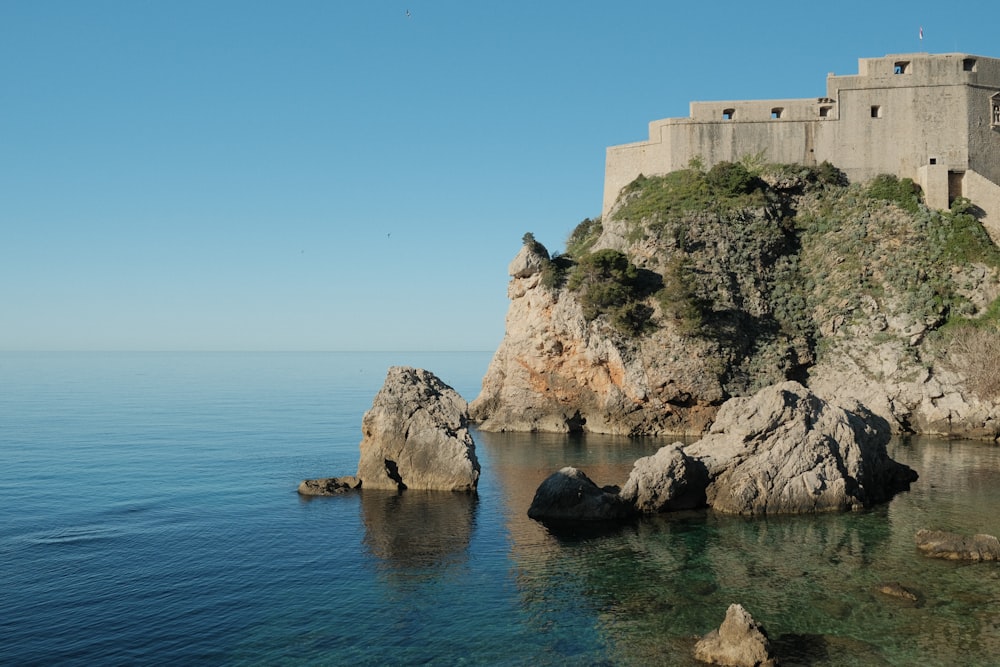a castle sitting on top of a cliff next to the ocean