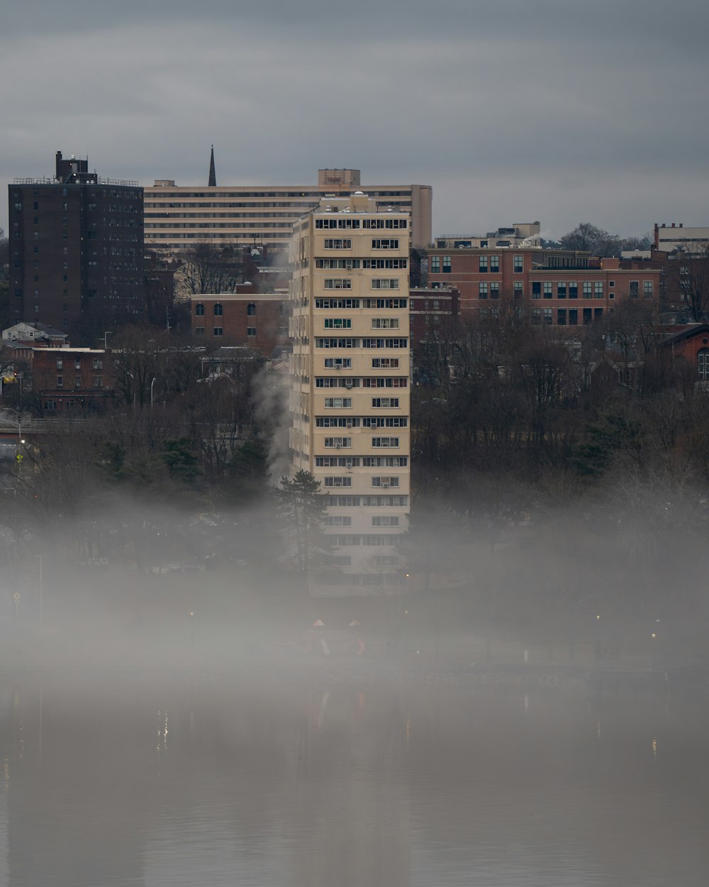 a tall building in the middle of a foggy city