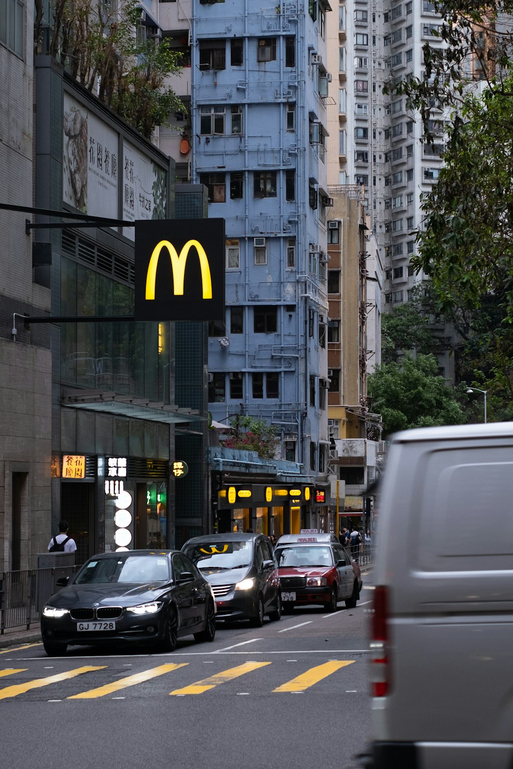 a city street with cars and a mcdonald's sign