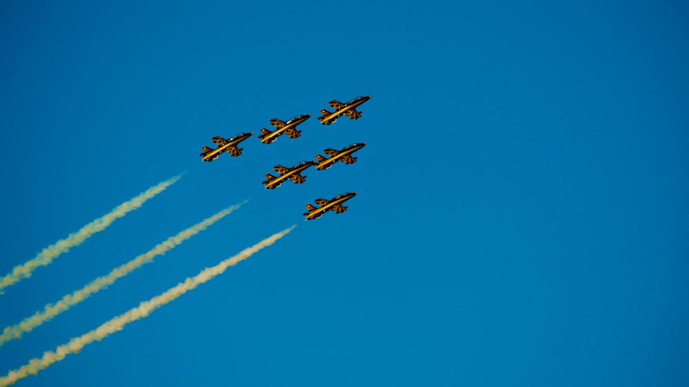 four airplanes flying in formation in a blue sky