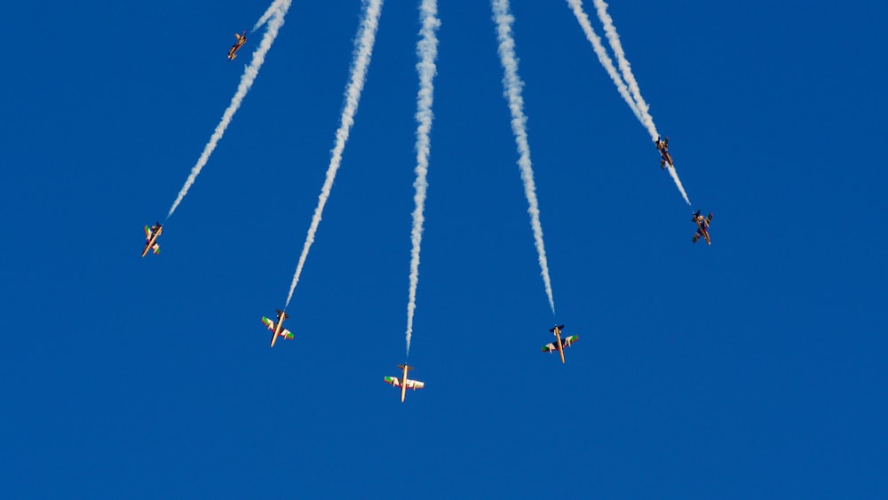 a group of airplanes flying through a blue sky