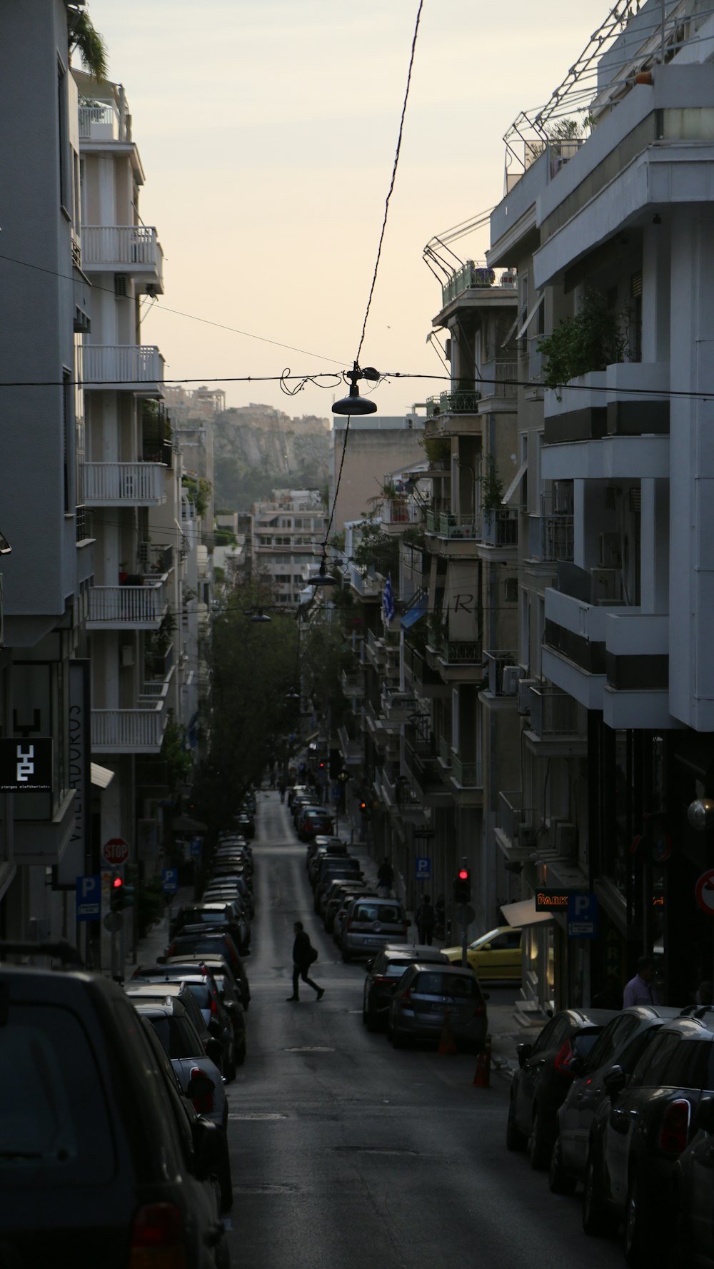 a city street filled with lots of traffic next to tall buildings