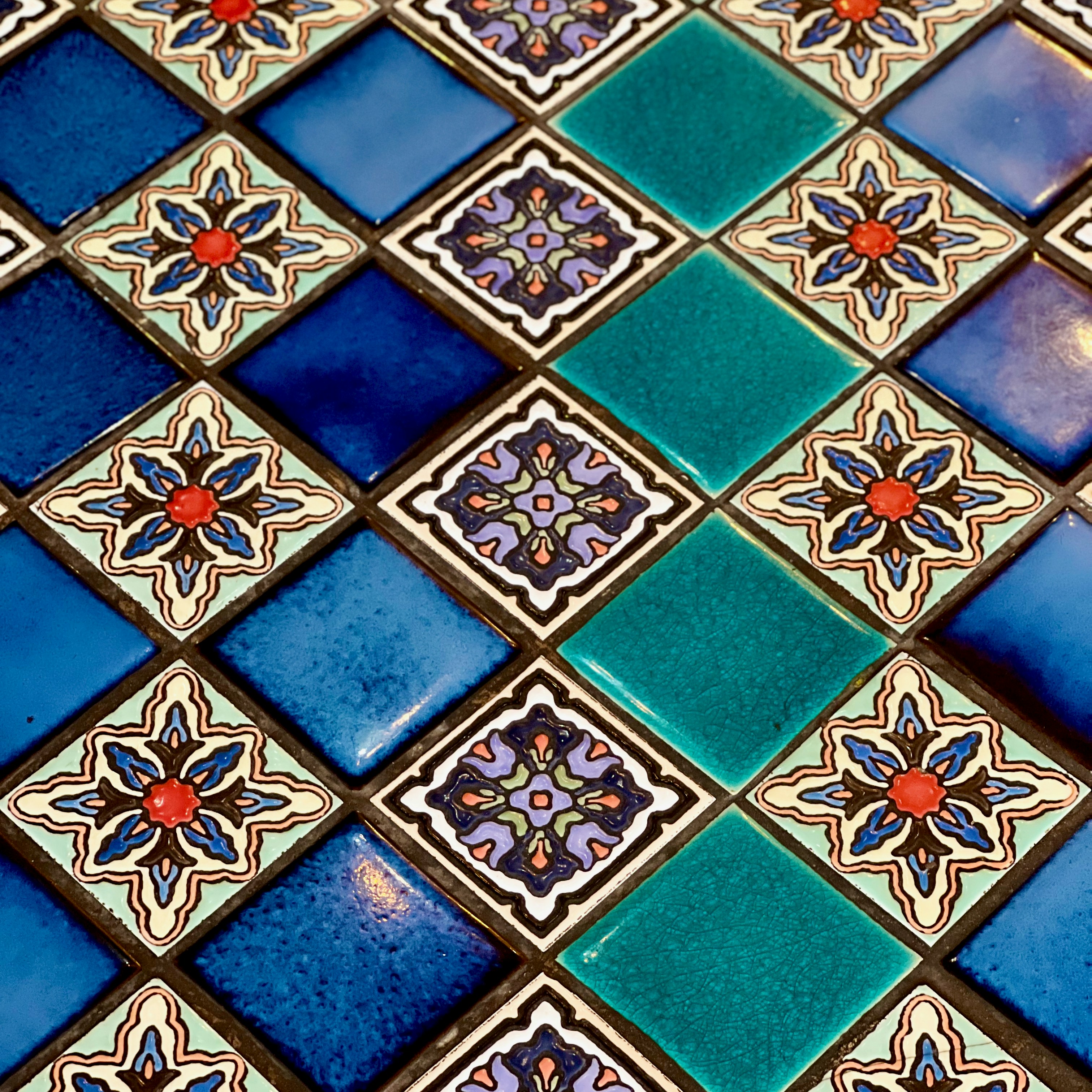 a close up of a blue and green tile wall