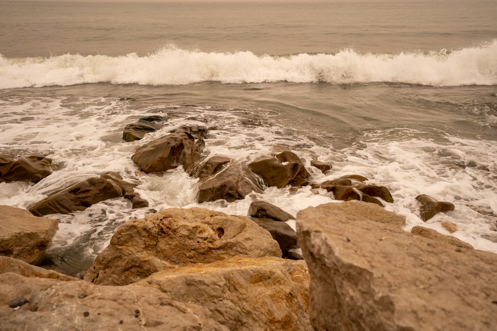 a large body of water sitting next to a rocky shore