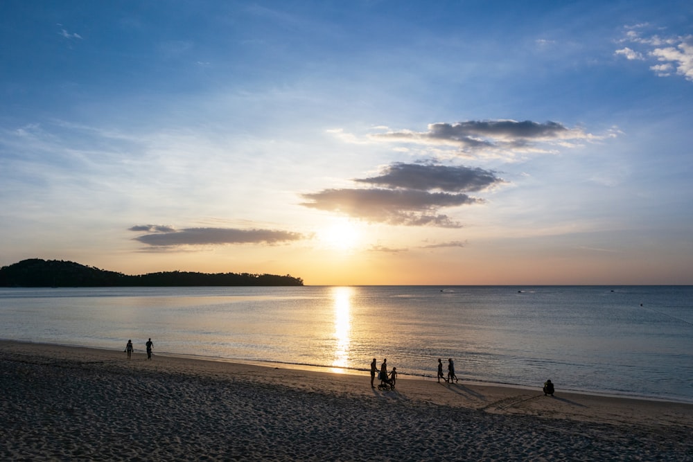 a group of people standing on top of a sandy beach