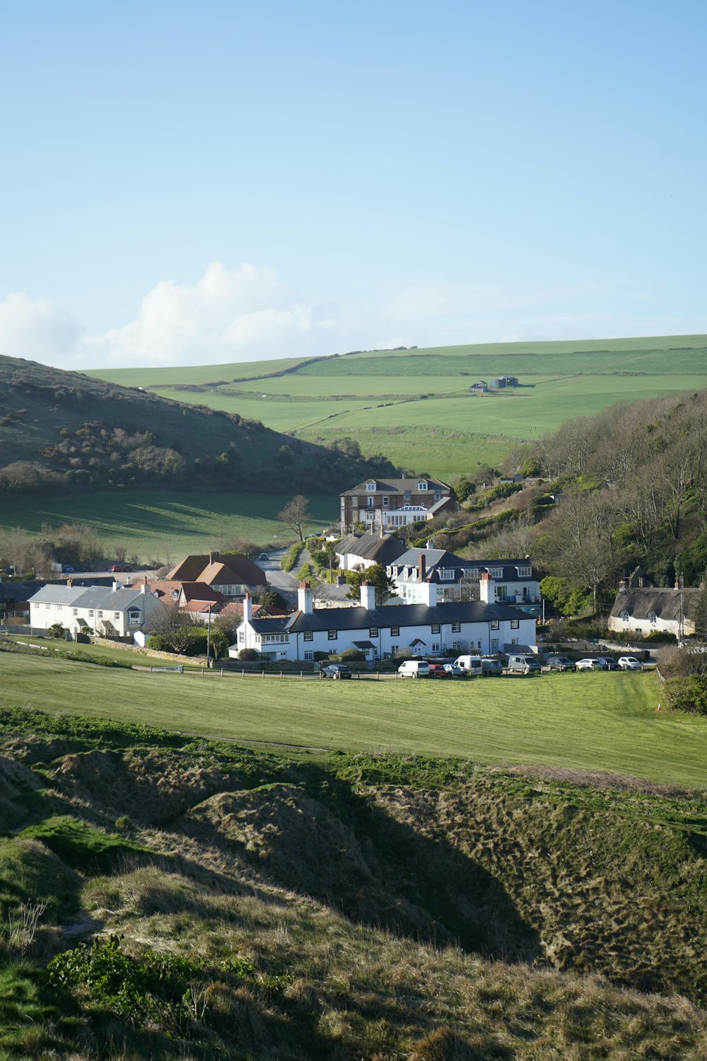 a large white house sitting on top of a lush green hillside