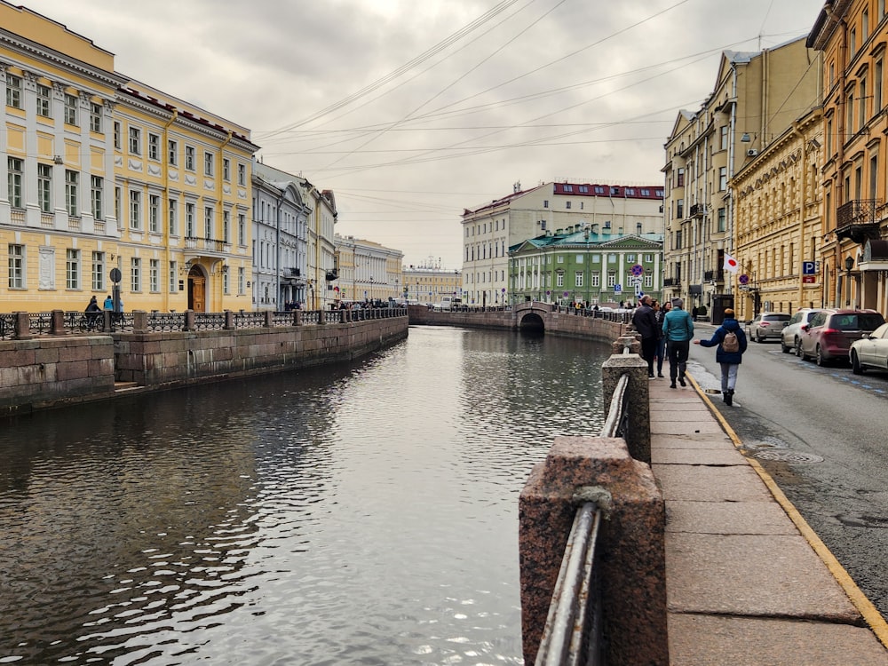 people walking along a canal in a city