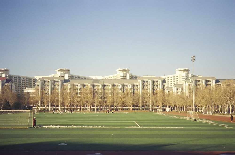 a large building with a soccer field in front of it