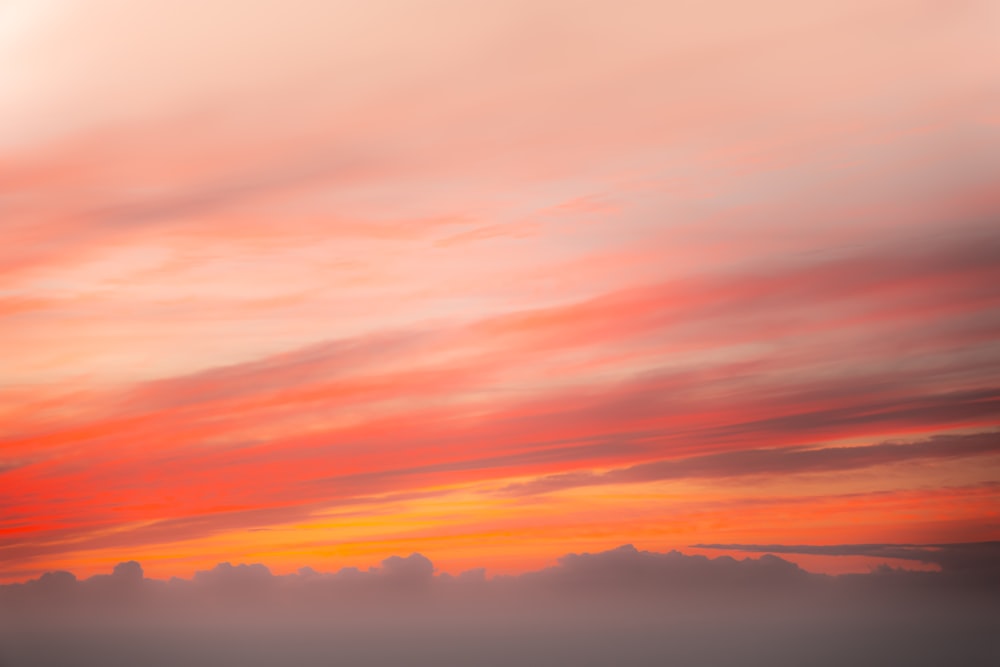 a plane flying in the sky at sunset