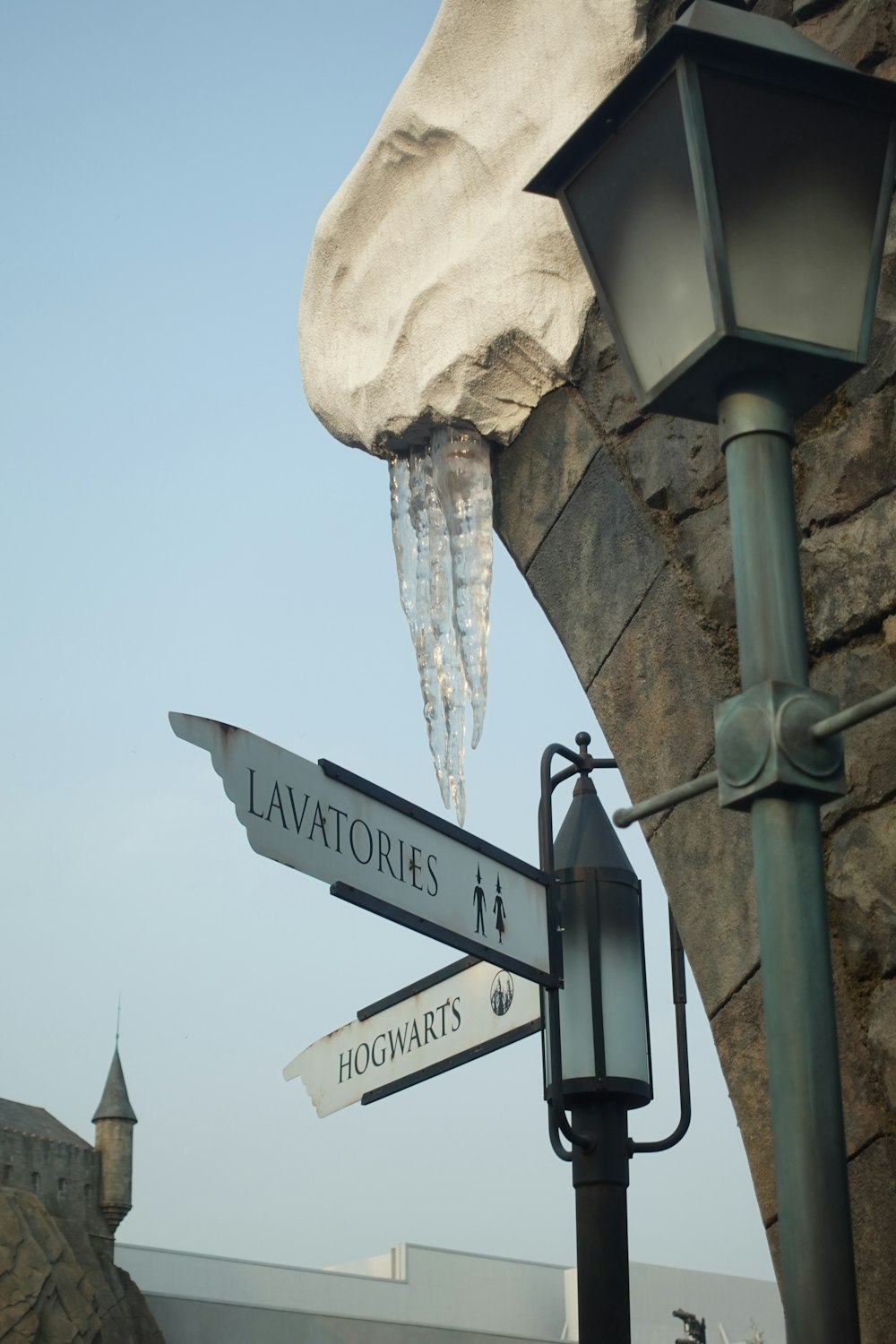 ein Straßenschild, an dessen Seite Eis hängt