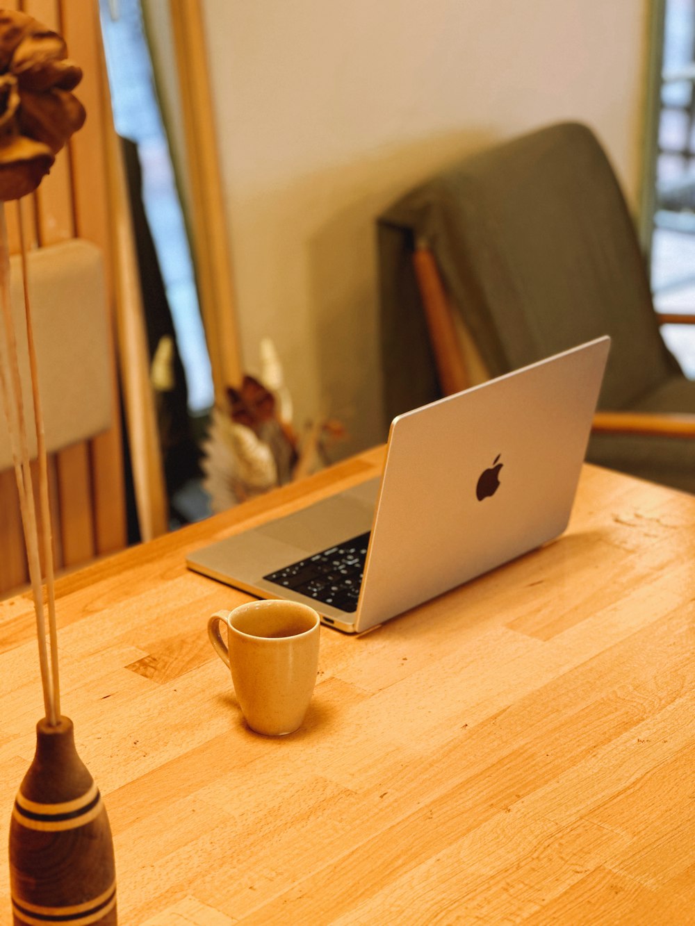 un ordinateur portable posé sur une table en bois