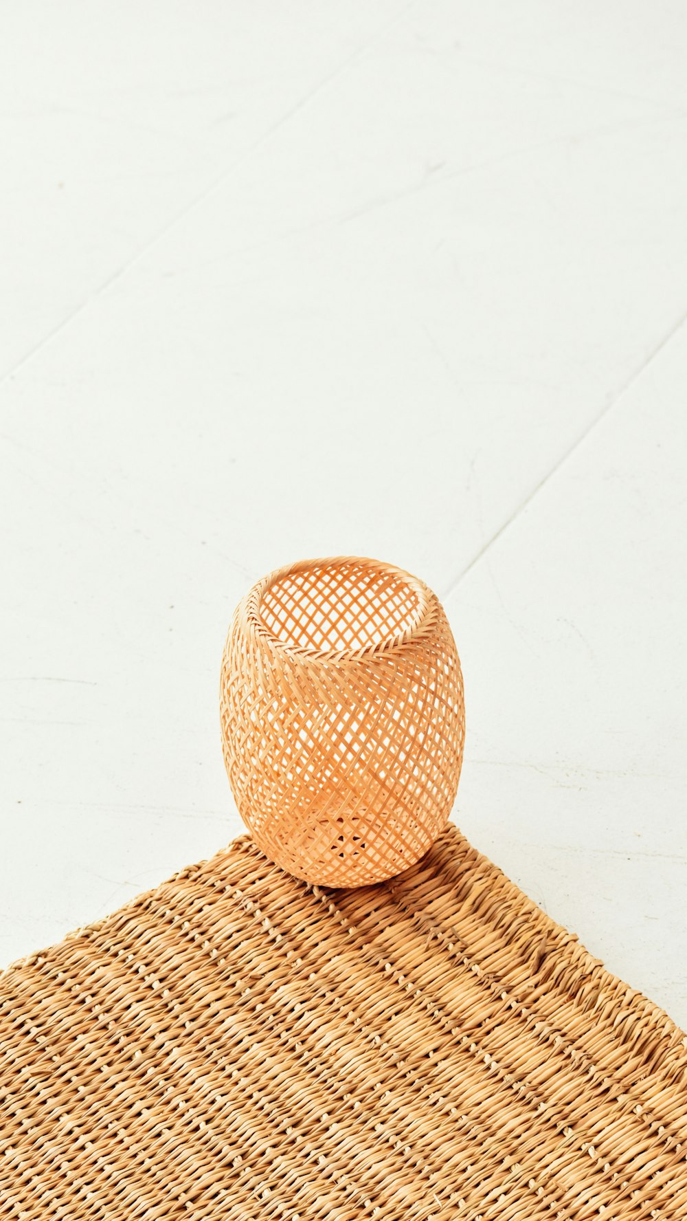 a wicker vase sitting on top of a mat