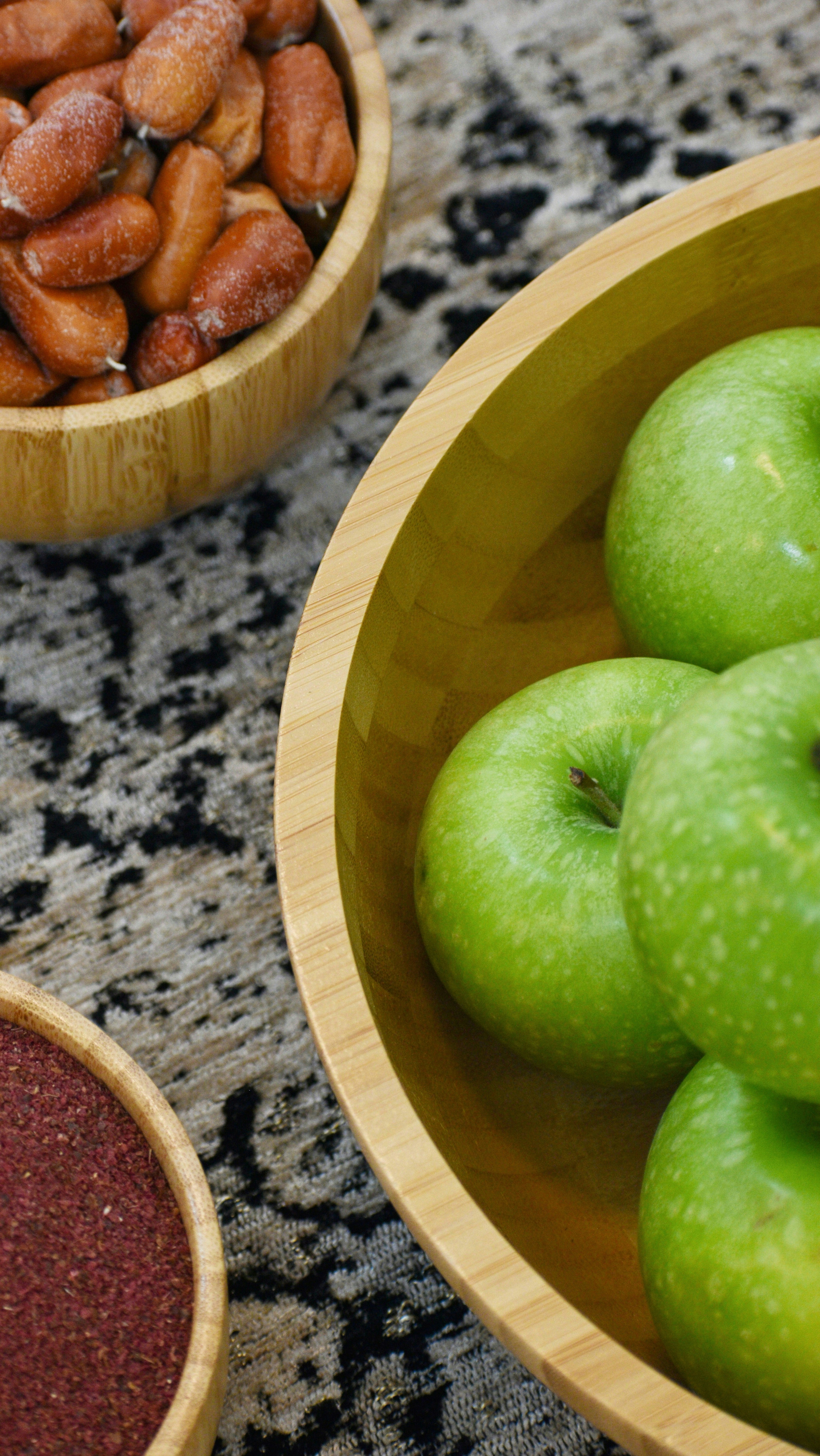 a couple of bowls filled with green apples and almonds