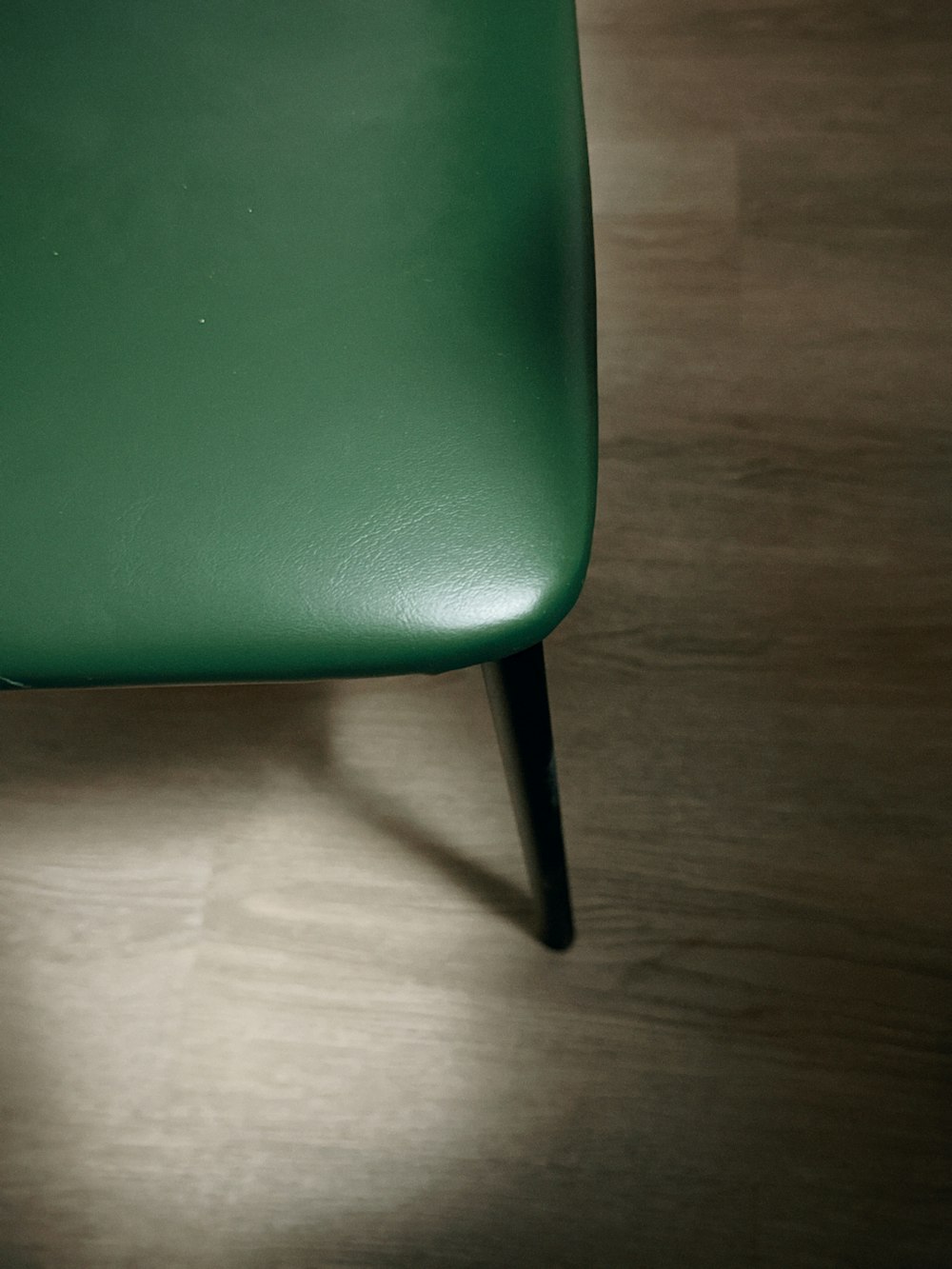 a green chair sitting on top of a wooden floor