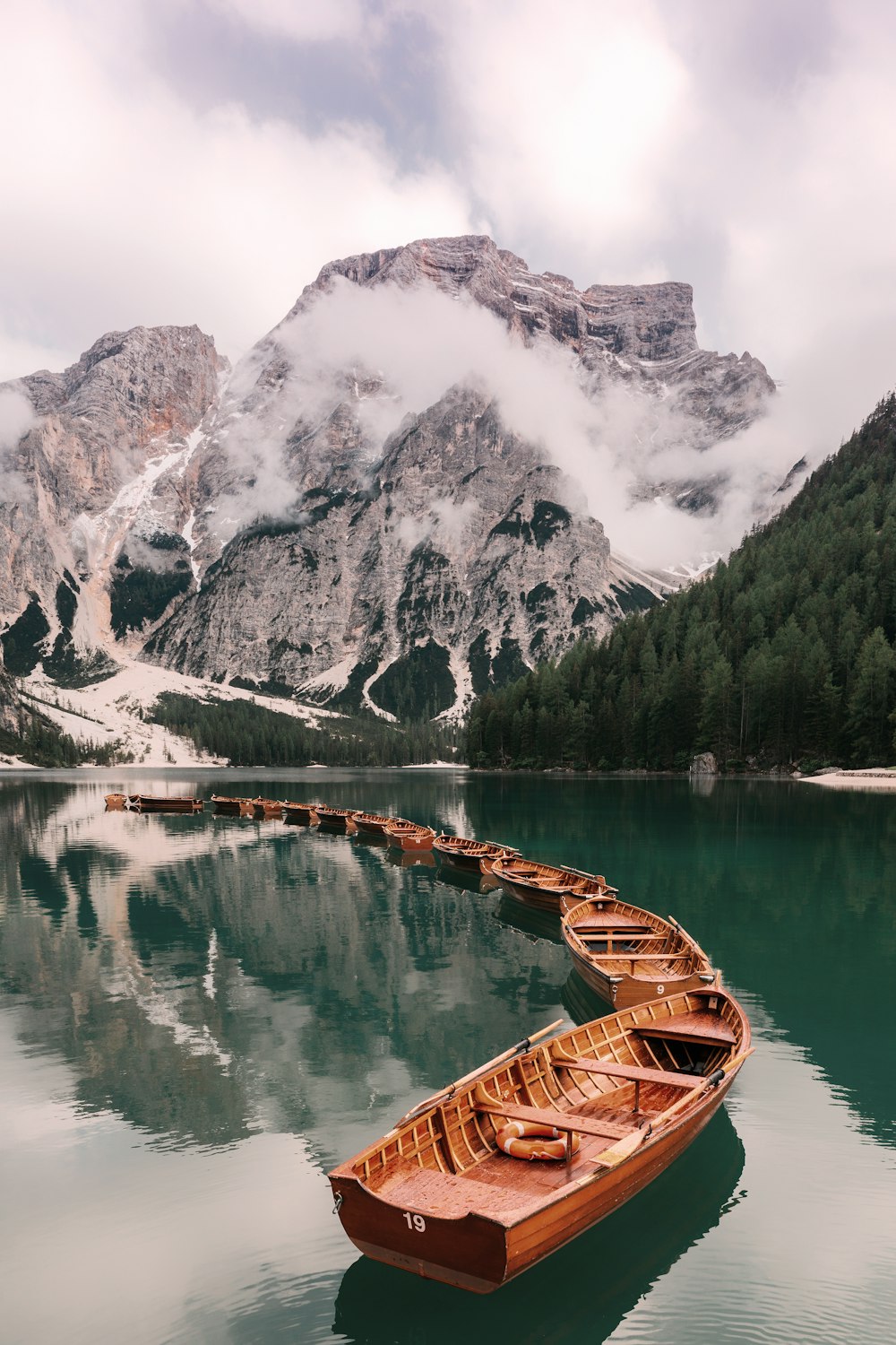 una barca a remi seduta in cima a un lago vicino a una montagna