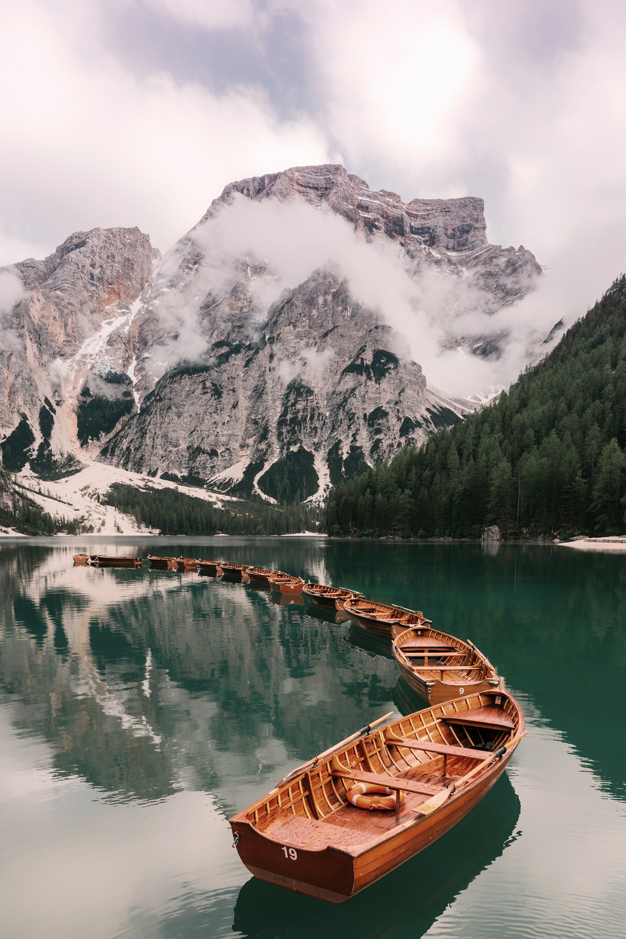 a row boat sitting on top of a lake next to a mountain