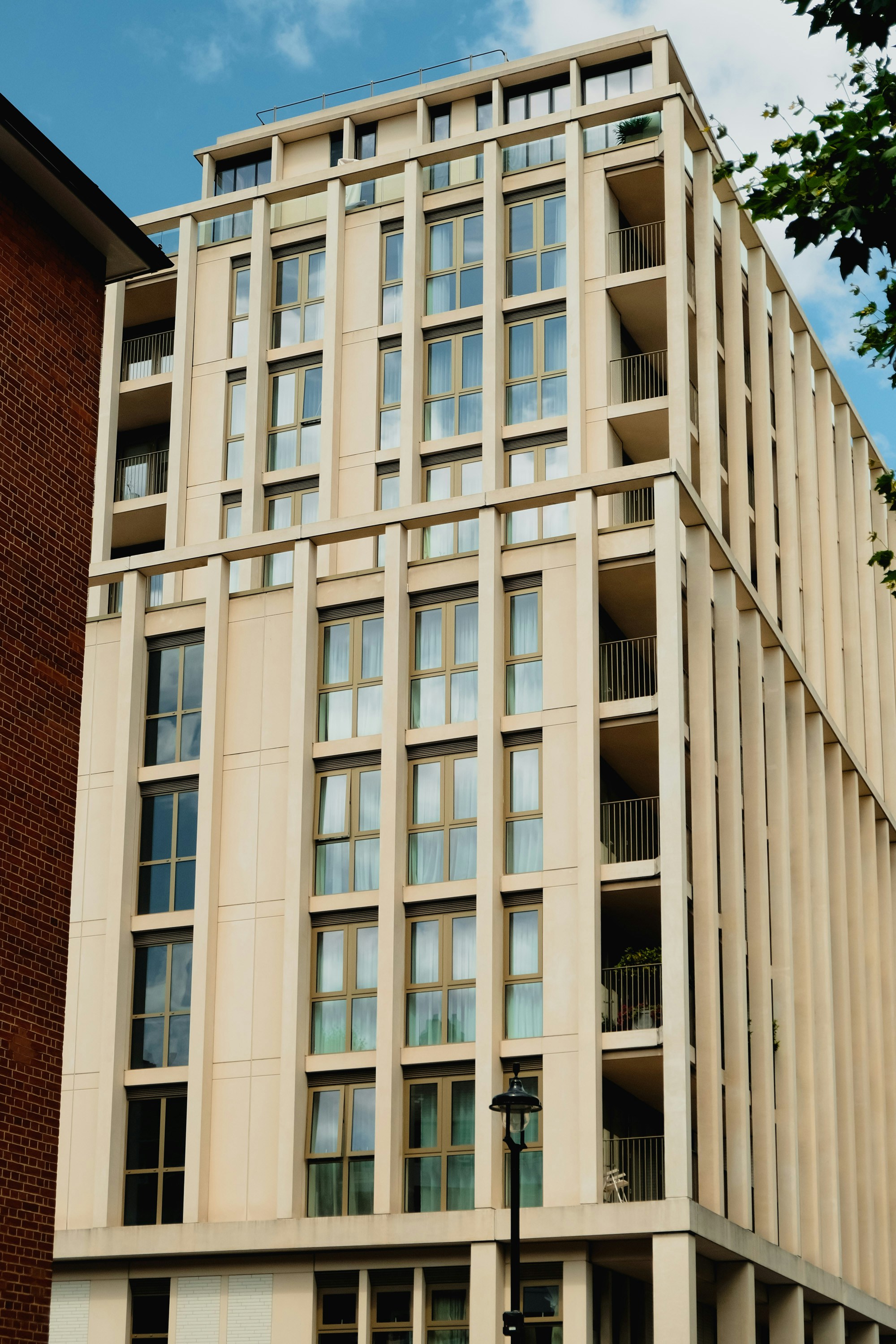 a tall building with lots of windows next to a tree